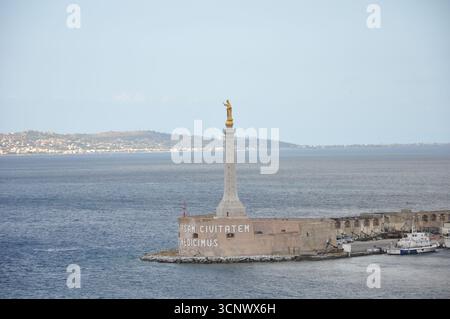 Eine Statue unserer Dame des Briefes am Eingang des Hafens von Messina. Meer im Hintergrund an einem sonnigen Tag Stockfoto