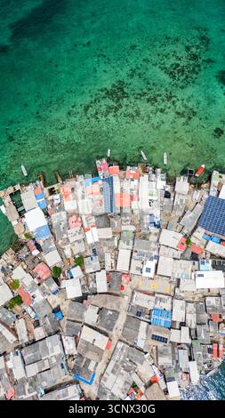 Blick aus der Vogelperspektive auf Santa Cruz del Islote, die am dichtesten besiedelte Insel der Welt, mit farbenfrohen Dächern und klarem karibischem Wasser, das lebendig ist Stockfoto