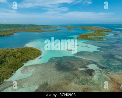 Aus der Vogelperspektive das türkisfarbene Wasser umgibt die grünen Inseln des Parque Nacional Morrocoy unter einem riesigen, azurblauen Himmel, Parque Nacional Morrocoy, Falcón, Venezuela. Stockfoto