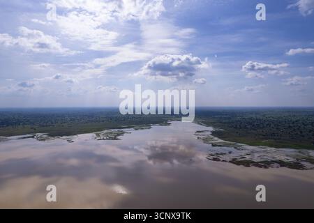 Aus der Vogelperspektive auf den sich windenden, schlammigen Fluss, der die Wolken darüber reflektiert und durch den üppigen grünen Wald führt, Babanruga, Kano, Nigeria. Stockfoto