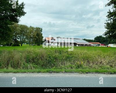 Traunreut, Deutschland - 24. September 2022: Grüne Felder umgeben moderne Bauernhäuser mit Solardächern in Deutschland. Stockfoto