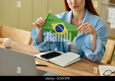 Der rothaarige Lehrer führt zu Hause eine Online-Lektion über brasilianische Sprache und Kultur durch. Stockfoto