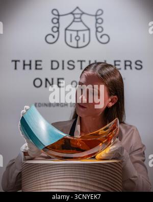 London, England, Großbritannien. September 2025. Ein Mitarbeiter von Sotheby's posiert mit der Glenlivet SPIRA 60 Year Old 1965 während einer Pressevorschau für The Distillers One of One Auction bei Sotheby's in London, Großbritannien am 23. September 2025. Die Auktion findet am 10. Oktober im Hopetoun House in der Nähe von Edinburgh statt. Quelle: ZUMA Press, Inc./Alamy Live News Stockfoto