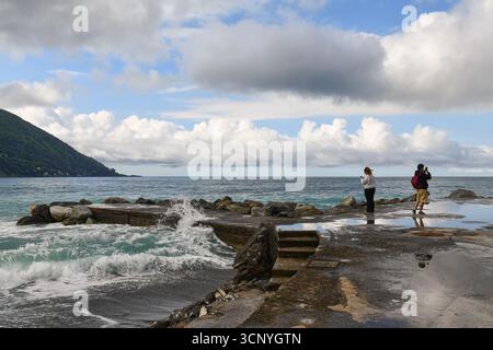 Molo Rivo Giorgio, ein kurzer Mole am Ufer des Ferienorts, wo Touristen an einem stürmischen Tag Fotos machen, Camogli (Genua), Italien Stockfoto