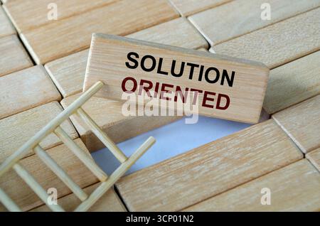 Lösungsorientierter Text auf Holzblöcken auf einer Leiter, der Problemlösungsstrategien und Anpassungsfähigkeit symbolisiert Stockfoto