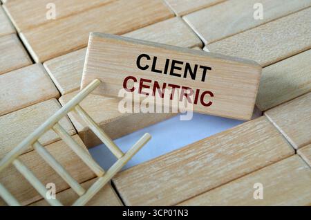 Kundenorientierter Text auf Holzblöcken auf einer Holzleiter, der den Fokus auf den Kunden und den exzellenten Service unterstreicht Stockfoto