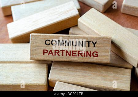 Auf Holzblöcken geschriebener Text für gemeinschaftliche Partnerschaften, der kollektive Maßnahmen für die soziale Entwicklung darstellt Stockfoto