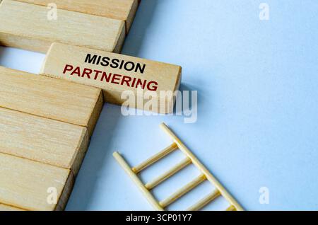 Text der Mission Partnering auf einem Holzblock auf einer Leiter, der zielgerichtete Ziele und Richtung veranschaulicht Stockfoto