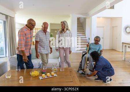 afroamerikanerin, die im Rollstuhl sitzt, zu Hause eine Pflegekraft, die Schuh anpasst, Kopierraum Stockfoto