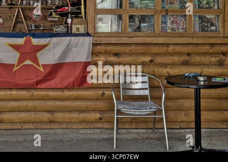 Bosnien und Herzegowina, Drvar (Mun.), Drvar (Titov Drvar): Museum 25. Mai ('Spomen kompleks / Muzej „25. Maj“ Drvar') – Stuhl und jugoslawische Flagge Stockfoto