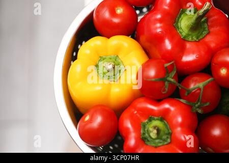 Frische rote und gelbe Paprika in einer weißen Schüssel. Bio-Gemüse zum Kochen. Gesunde Lebensmittel Nahaufnahme. Natürliches Ernährungskonzept. Stockfoto