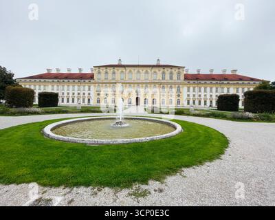 Oberschleissheim, Deutschland - 25. September 2022: Historisches deutsches Schloss Schleissheim mit Rundbrunnen, gepflegten Rasenflächen und symmetrischen Gärten. Stockfoto