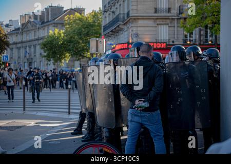 Demonstrant (Agent Provokateur in diesem Fall) steht vor Polizeibeamten in Anti-Aufruhr-Aktiva. Stockfoto