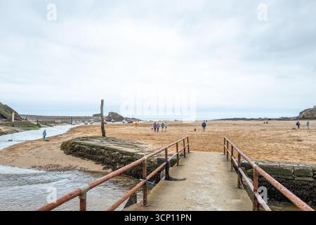 Der Betonweg über den Fluss Strat führt bei Ebbe zum Summerleaze Beach an der Nordküste Cornwalls bei Bude, Cornwall. Stockfoto