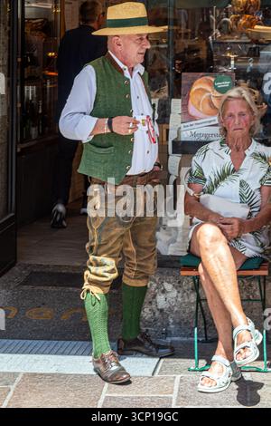 SALZBURG, ÖSTERREICH - 19. JULI 2025: Seniorenpaar in traditionellen österreichischen Trachten vor einem Tiroler Fachgeschäft. Stockfoto