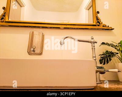 Wasserhahn in Vintage-Silber mit fließendem Wasser mit Waschbecken und Seifenspender. Hochwertige Fotos Stockfoto