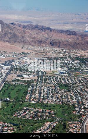 Blick aus der Vogelperspektive auf die Vororte von Las Vegas mit Wohnvierteln, grünen Golfplätzen und den umliegenden Wüstenbergen unter klarem Himmel Stockfoto