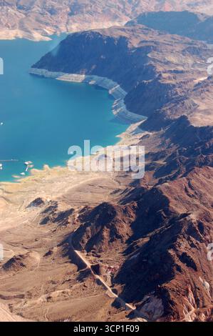 Blick aus der Vogelperspektive auf Lake Mead mit zerklüfteten Wüstenbergen und steilen felsigen Klippen entlang der Küste, die Veränderungen des Wasserspiegels und trockene Landschaft zeigen Stockfoto