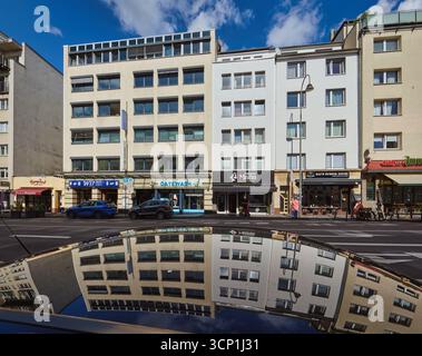 Auf dem Dach Eines Autos spiegeln sich Reihenhäuser mit Apartments, Restaurants und Geschäften in der Christophstraße in der Kölner Altstadt Stockfoto