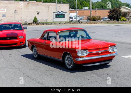 Maiden, North Carolina, USA-14. Juli 2025: Klassischer roter Chevrolet Corvair wird vom späteren Ford Mustang verfolgt. Stockfoto