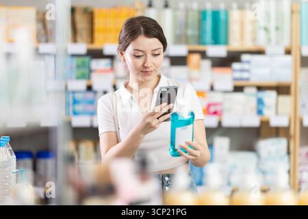 Die Frau scannt ein Mundwasser auf ihrem Handy Stockfoto