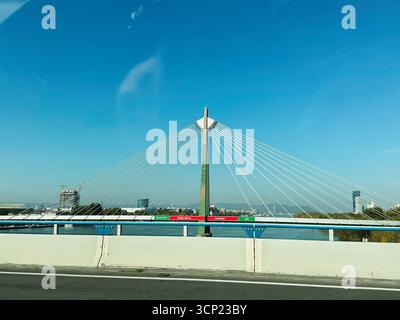 Wien, Österreich - 22. Oktober 2024: Eine Seilbrücke Donaustadtbrücke überspannt den Fluss unter klarem blauem Himmel, von einer Straßensperre aus gesehen Stockfoto