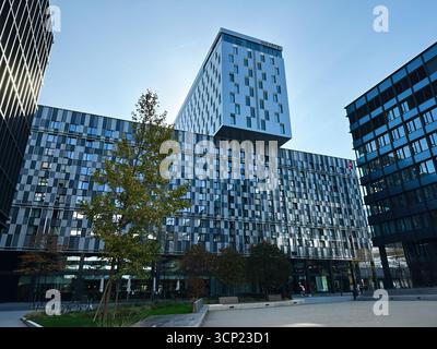 Wien, Österreich - 22. Oktober 2024: Ein eleganter Bürokomplex des Novotel Wien Hauptbahnhof mit Glaswänden, Bäumen und offener plaza für Besucher Stockfoto