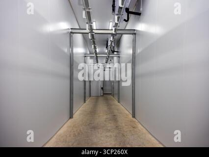 Schlachthoffabrik, Gebäude für Kühlräume und Tiefkühltruhen, Lagersysteme für die Doppelschiene im Flur, keine Leute Stockfoto
