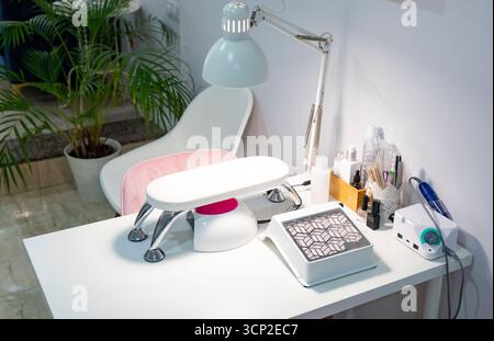 Moderner Manikürraum in einem Schönheitssalon. Tisch, Werkzeuge und Ausrüstung für einen Nageltechniker Stockfoto