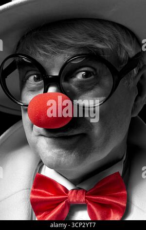 Nahaufnahme selektives Farbporträt eines Clown. Ein älterer Mann mit weißem Mantel und Hut. Stockfoto