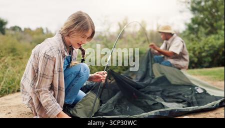 Paare, Stellplätze und Zelte für Camping in der Natur für Reiseausrüstung, Urlaubsabenteuer und die Verbindung miteinander. Menschen, Hilfe und Einrichtung von Ausrüstung für den Außenbereich Stockfoto