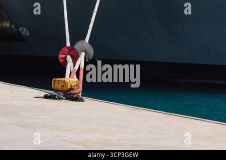 Festmachen eines Schiffes im Hafen mit Festmacherleinen an einem Schiffspoller am Kai Stockfoto