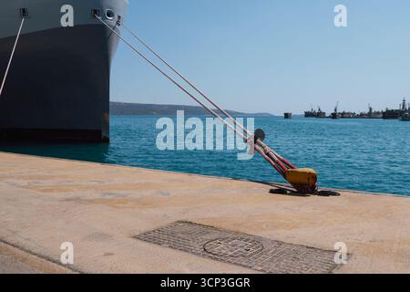 Festmachen eines Schiffes im Hafen mit Festmacherleinen an einem Schiffspoller am Kai Stockfoto