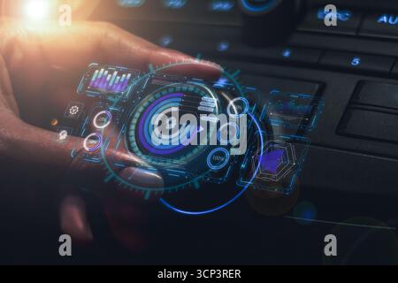 Die Hand einer Verkäuferin demonstriert die Fahrzeugtechnik mit einem virtuellen Hologramm aus blauem Licht auf dem Armaturenbrett. Stockfoto