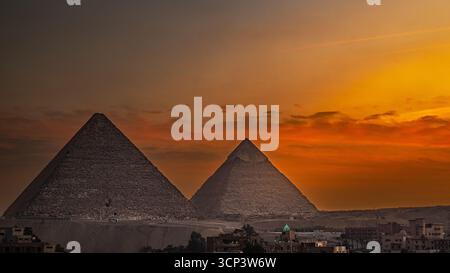Zwei Pyramiden leuchten warm unter dem goldenen Licht des Sonnenuntergangs Stockfoto