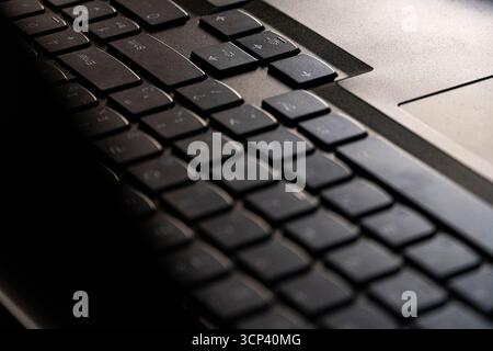 Makroaufnahme einer modernen Laptop-Tastatur in warmem, weichem Licht. Perfekt für Konzepte wie Technologie, Fernarbeit, Büroausstattung oder digitale Kommunikation Stockfoto
