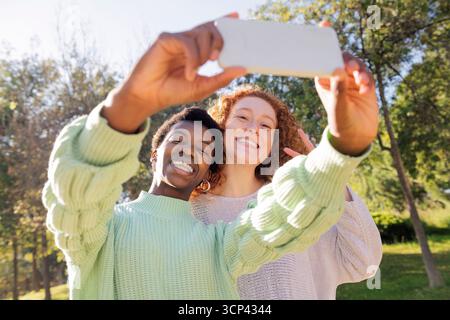 Zwei glückliche junge Frauen machen ein Selfie mit dem Telefon Stockfoto