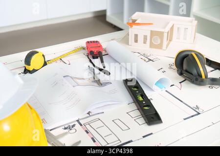 Technische Werkzeuge und Pläne für ein Bauprojekt auf einem Tisch Stockfoto