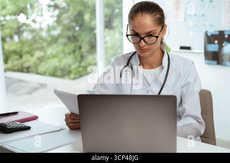 Arztpraxis liest Papierdokumente und überprüft die Krankenakte in der Krankenhauspraxis. Medizinkonzept Stockfoto