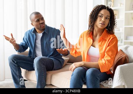 Afroamerikanisches Paar streitet zu Hause, eine Frau wendet sich mit Protest ab Stockfoto