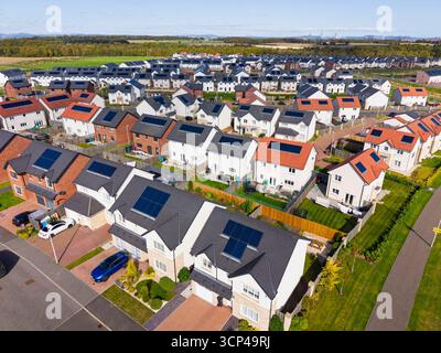 Luftaufnahme von Häusern mit Solarpaneelen auf Dächern in der neuen Wohnsiedlung in Winchburgh, West Lothian, Schottland, Großbritannien Stockfoto