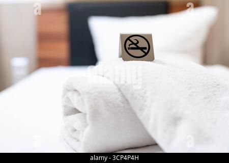 Deutschland - 20. September 2025: Ein Verbotsschild mit einem Symbol für Nichtraucher steht auf dem Bett des Hotelzimmers und macht deutlich, dass in diesem Zimmer ein Rauchverbot besteht *** ein Verbotsschild mit Symbol für Nichtraucher steht im Hotelzimmer auf dem Bett und macht deutlich, dass in diesem Raum ein Rauchverbot gilt Stockfoto