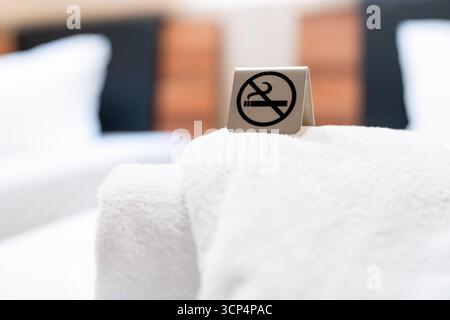 Deutschland - 20. September 2025: Ein Verbotsschild mit einem Symbol für Nichtraucher steht auf dem Bett des Hotelzimmers und macht deutlich, dass in diesem Zimmer ein Rauchverbot besteht *** ein Verbotsschild mit Symbol für Nichtraucher steht im Hotelzimmer auf dem Bett und macht deutlich, dass in diesem Raum ein Rauchverbot gilt Stockfoto
