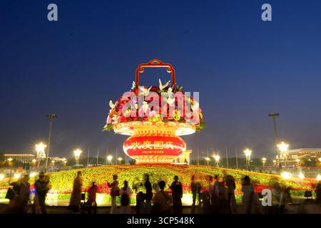 Touristen besuchen am Abend des 24. September 2025 das Blumenbeet zum Nationalfeiertag im Kernbereich des Tiananmen-Platzes in Peking, China. Stockfoto