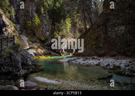Malerische Schlucht Orrido dello Slizza in der Nähe von Tarvisio, Italien, mit klarem türkisfarbenem Wasser, das zwischen steilen felsigen Klippen fließt, umgeben von üppigem Wald Stockfoto