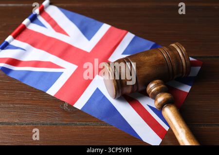 Richterlicher Hammer und Flagge von Großbritannien auf Holztisch, Nahaufnahme Stockfoto