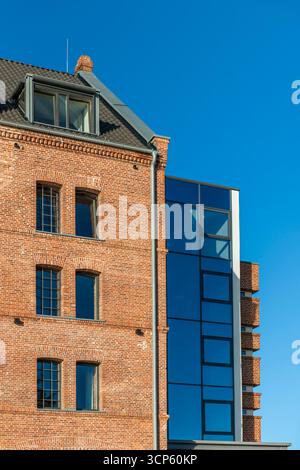 Teilansicht der gemischten Architektur der Stadt leer in Ostfriesland mit modernisierten Altbauten vor blauem Himmel. Stockfoto