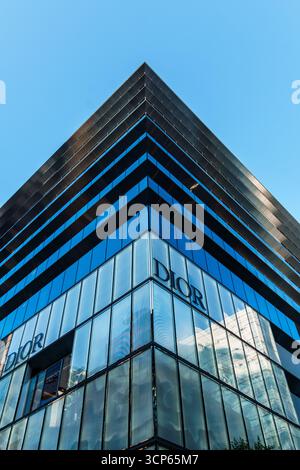 Tokio, Japan - 3. August 2024: Das moderne Dior-Gebäude in Ginza, Tokio, mit seiner eleganten Glasfassade und dem klaren blauen Himmel darüber. Stockfoto