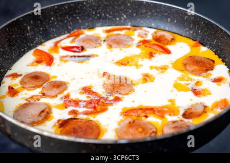 Omelette mit Pilzen und roten Paprika in einer Pfanne kochen. Leckeres hausgemachtes Frühstück. Stockfoto
