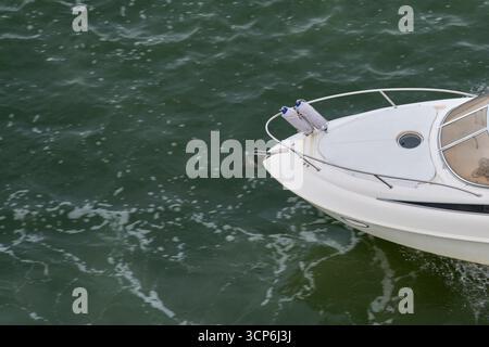 Diese dynamische Komposition zeigt rechts die Vorderseite eines fahrenden Bootes, wobei links eine große Fläche von offenem Wasser für Kopierraum und Text übrig bleibt Stockfoto